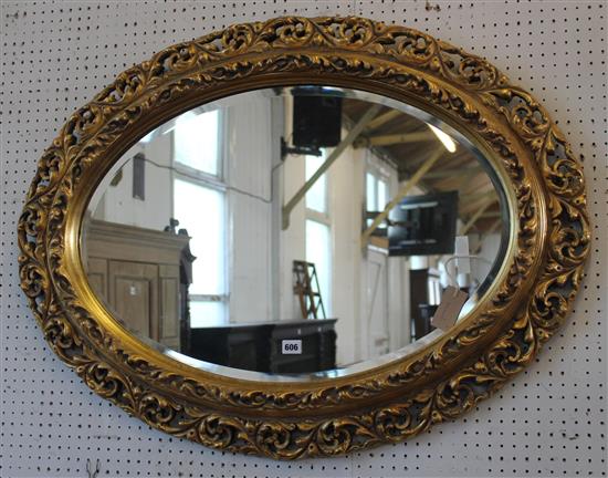 Gilt-framed oval wall mirror